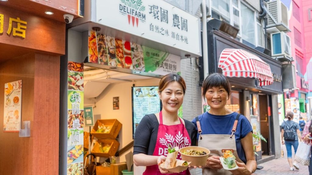 「絲打同行」創辦人Vivian（左）與素食媽咪（右）聯同「Innolife環圃休閒村」，在荔枝角合作「Delifarm 環圃．農圃」外賣小店，推出由素媽主理的純素餐單，以本地有機蔬食製作各款素食便當，讓城市人更方便吃到健康有機素食。